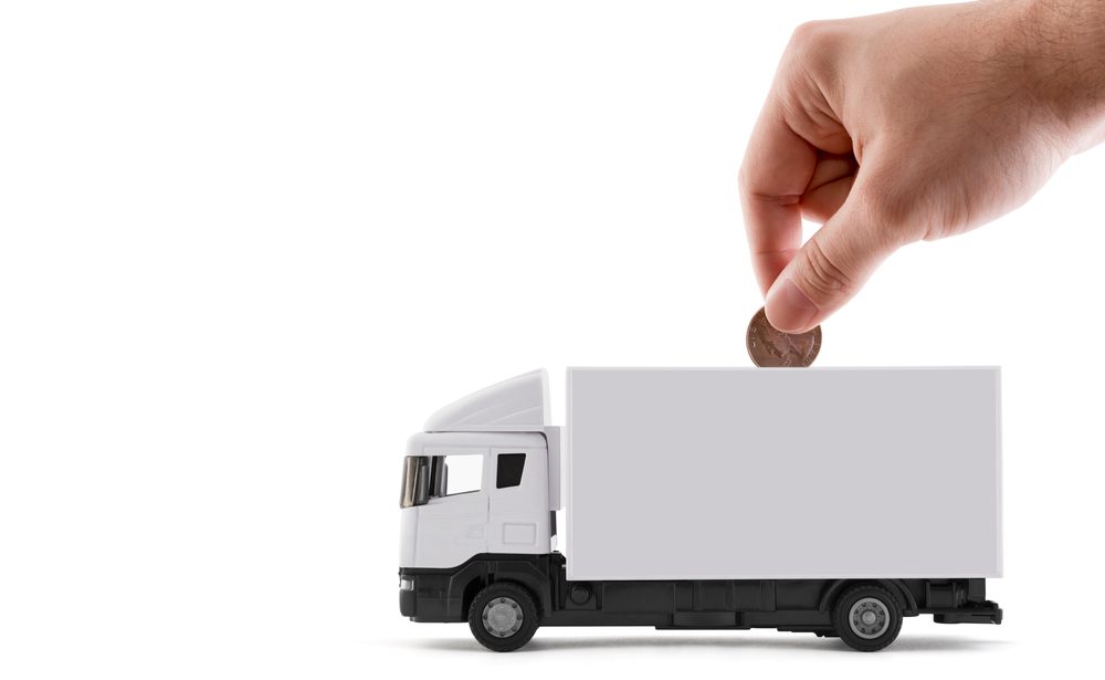 Putting,Coin,Into,The,White,Cargo,Delivery,Truck,On,White